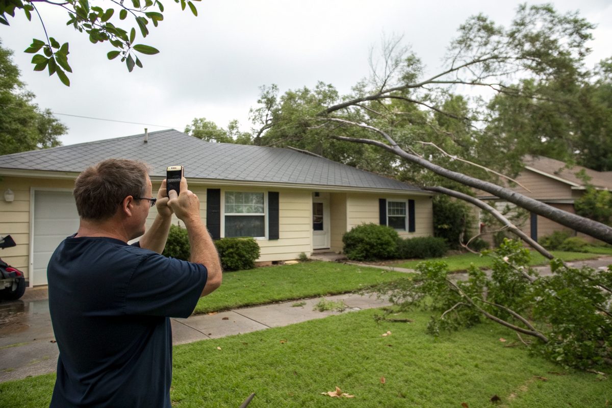 A homeowner photographing his roof after a storm